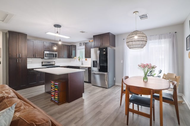 kitchen with light countertops, visible vents, stainless steel appliances, and dark brown cabinets