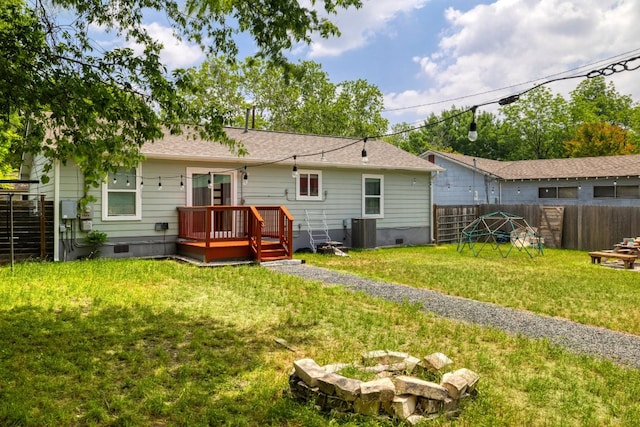 rear view of property featuring a lawn, crawl space, a wooden deck, and a fenced backyard