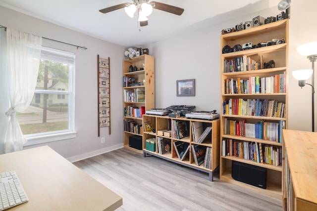 interior space with baseboards, ceiling fan, and wood finished floors