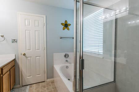 bathroom with a garden tub, a stall shower, and vanity