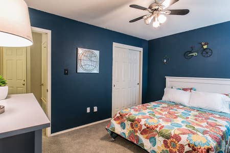 carpeted bedroom featuring baseboards, ceiling fan, and a closet