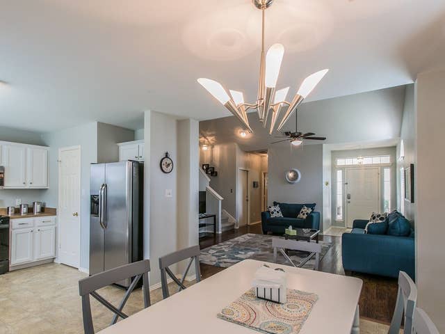 dining room featuring ceiling fan with notable chandelier and stairway