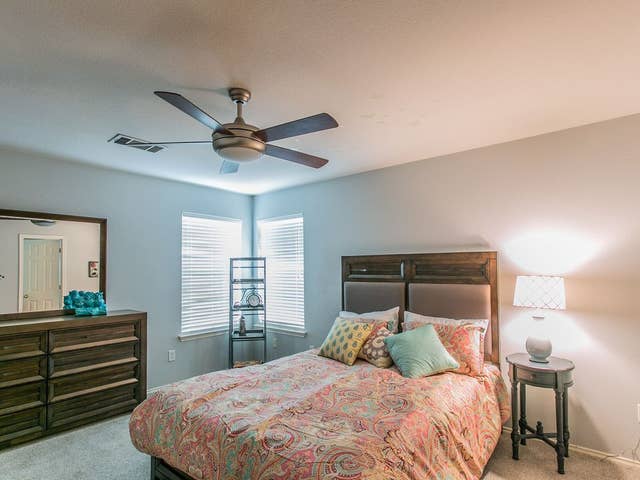 bedroom featuring carpet floors, ceiling fan, and visible vents