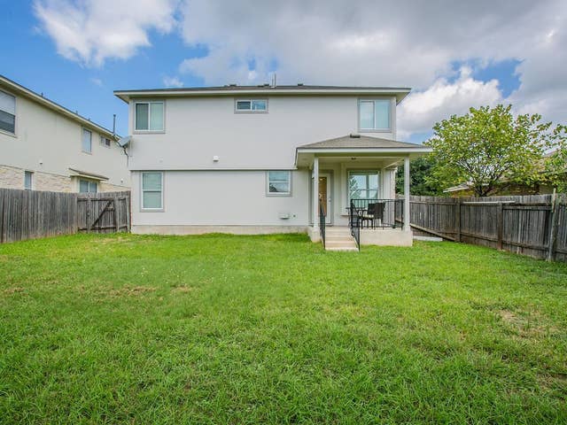rear view of house featuring a lawn, a fenced backyard, a patio area, and stucco siding