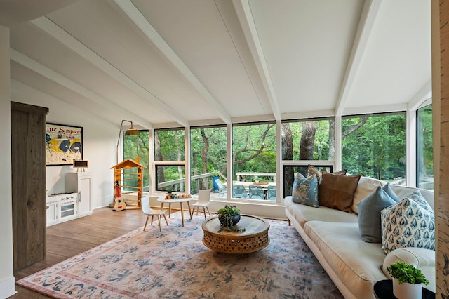 sunroom / solarium with vaulted ceiling with beams, baseboards, wood finished floors, and a deck