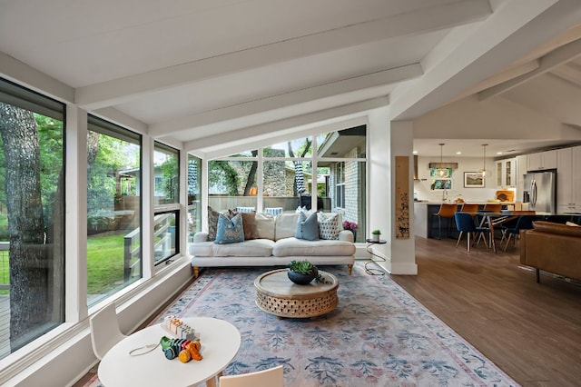 living room featuring plenty of natural light, lofted ceiling with beams, and dark wood-style flooring