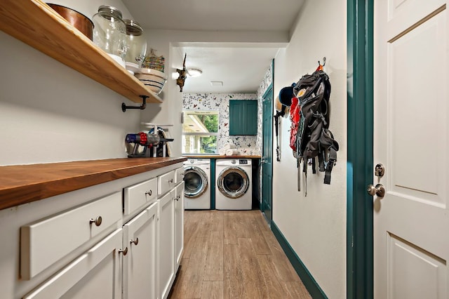 laundry area featuring cabinet space, washing machine and dryer, and light wood finished floors