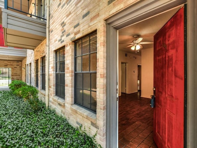 doorway to property featuring covered porch and brick siding