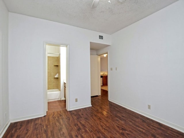 unfurnished bedroom with visible vents, baseboards, ceiling fan, dark wood-style floors, and a textured ceiling