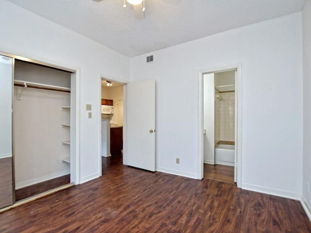 unfurnished bedroom with baseboards, visible vents, wood finished floors, and a closet