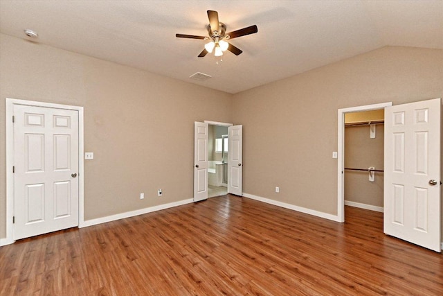 3705 Derby Trl, Round Rock, TX 78681 - unfurnished bedroom with wood finished floors, vaulted ceiling, a spacious closet, ensuite bathroom, and ceiling fan