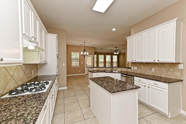 3705 Derby Trl, Round Rock, TX 78681 - kitchen with white gas stovetop, a chandelier, under cabinet range hood, white cabinets, and a peninsula