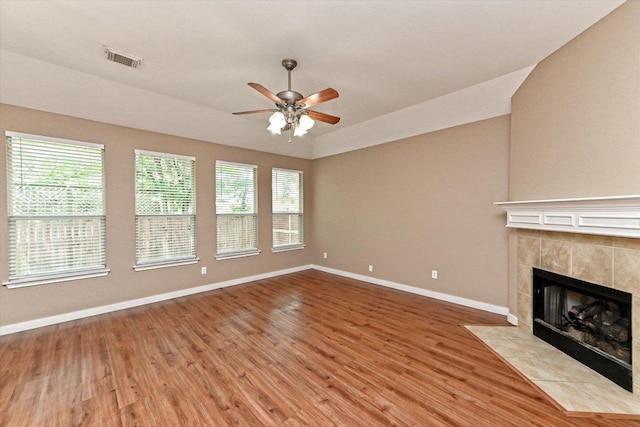 3705 Derby Trl, Round Rock, TX 78681 - unfurnished living room featuring a ceiling fan, wood finished floors, healthy amount of natural light, and a tiled fireplace