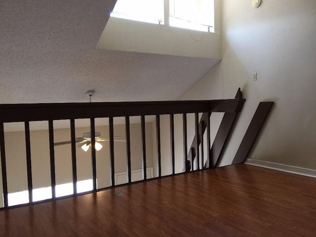 stairway with a ceiling fan and wood finished floors