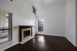 unfurnished living room with baseboards, a fireplace with flush hearth, and wood finished floors