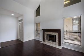 1910 Robbins Pl Unit 301, Austin, TX 78705 - unfurnished living room with wood finished floors, a tile fireplace, and a towering ceiling