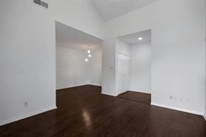 spare room featuring baseboards and wood finished floors