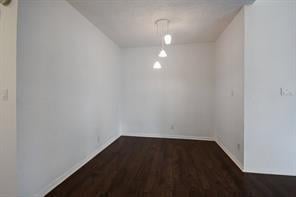 unfurnished dining area with baseboards and wood finished floors