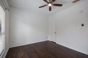 spare room featuring plenty of natural light, ceiling fan, and dark wood-style floors