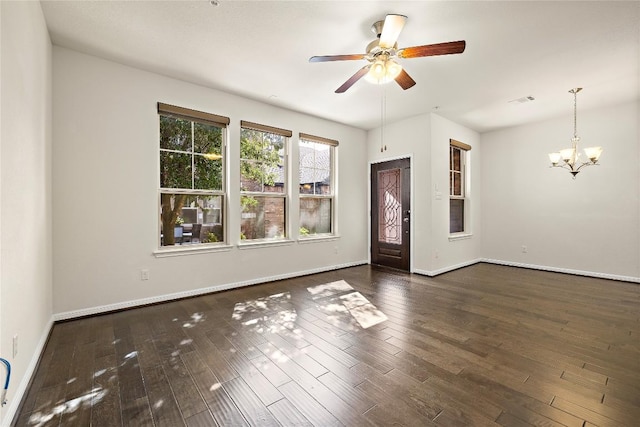 interior space with baseboards, visible vents, ceiling fan with notable chandelier, and dark wood-type flooring