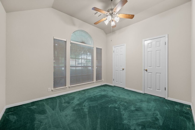 empty room with visible vents, dark colored carpet, baseboards, a ceiling fan, and vaulted ceiling