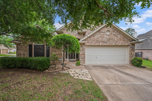 view of front of house featuring a garage, concrete driveway, and brick siding