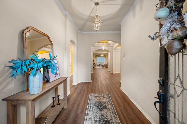 foyer with crown molding, arched walkways, baseboards, and wood finished floors