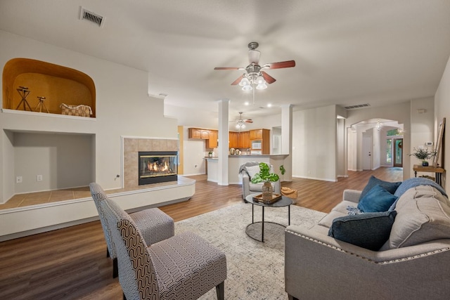 living room with visible vents, a ceiling fan, ornate columns, and wood finished floors