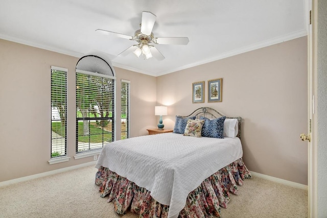 carpeted bedroom with crown molding, baseboards, and ceiling fan