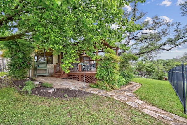 view of yard featuring fence, a wooden deck, and a patio area