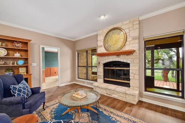 living room featuring baseboards, ornamental molding, a fireplace, and wood finished floors