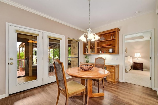 dining area featuring an inviting chandelier, ornamental molding, baseboards, and wood finished floors