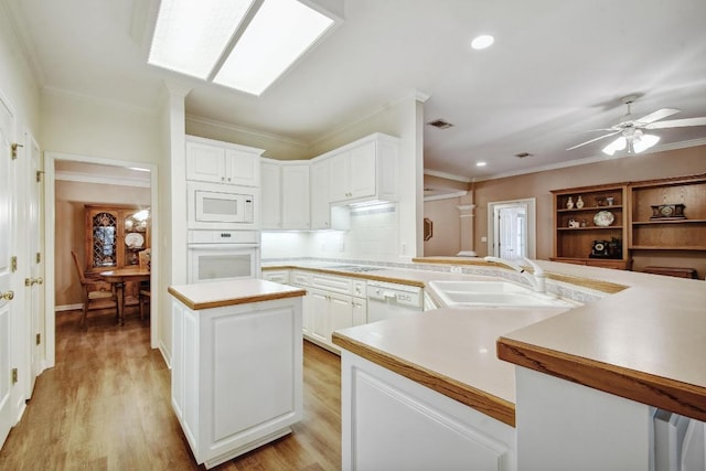 kitchen with ceiling fan, a sink, white appliances, light countertops, and ornamental molding