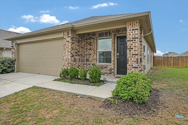 view of front of house with concrete driveway, brick siding, an attached garage, and fence