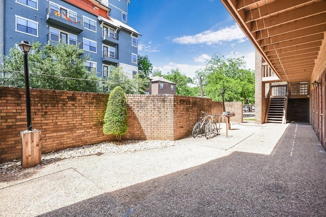 view of patio with fence and stairs