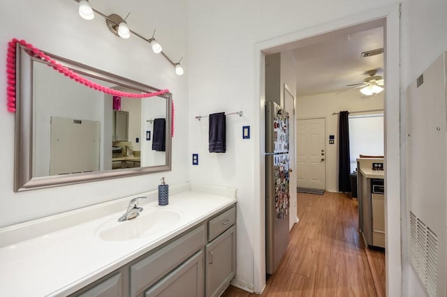 bathroom featuring vanity, ceiling fan, wood finished floors, and visible vents