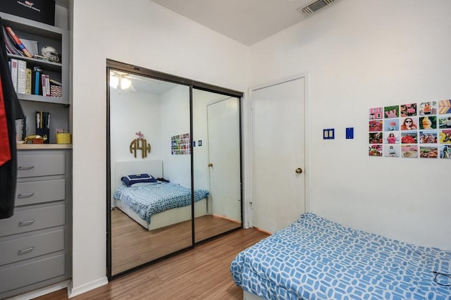 bedroom featuring visible vents, wood finished floors, and a closet