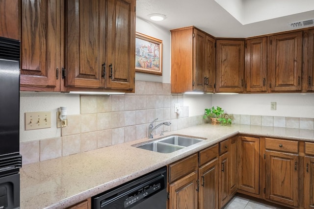 kitchen featuring visible vents, dishwasher, brown cabinets, a sink, and backsplash