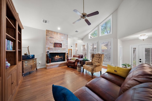 living area featuring visible vents, ceiling fan, wood finished floors, and high vaulted ceiling