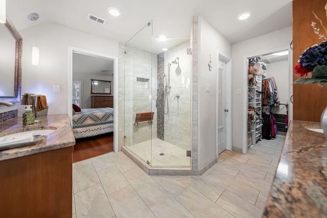 full bath with a walk in closet, visible vents, a shower stall, vanity, and ensuite bath