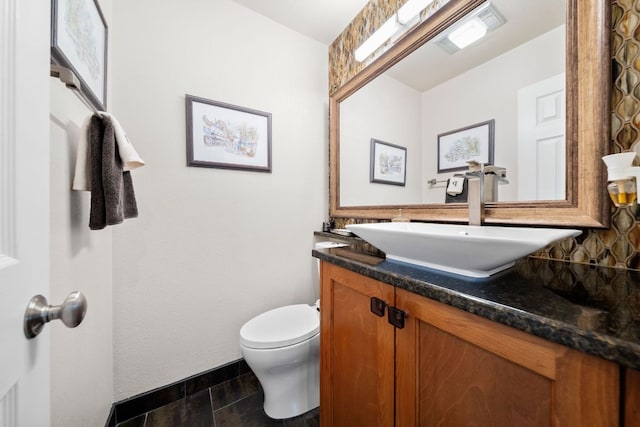 bathroom with vanity, visible vents, wood finished floors, toilet, and tasteful backsplash
