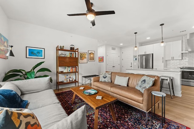 living room with ceiling fan, recessed lighting, light wood-style flooring, and visible vents