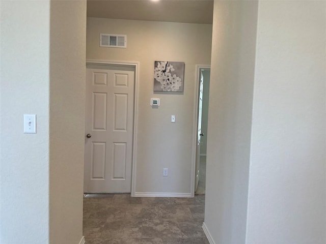 hallway with visible vents and baseboards