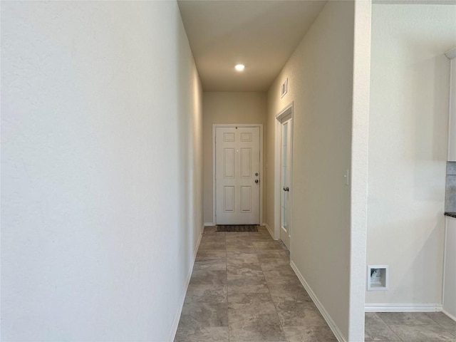 hall featuring baseboards and visible vents