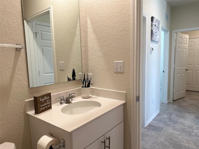 bathroom featuring vanity and a textured wall