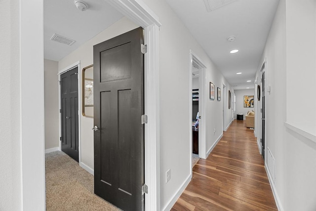 corridor with visible vents, recessed lighting, baseboards, and wood finished floors
