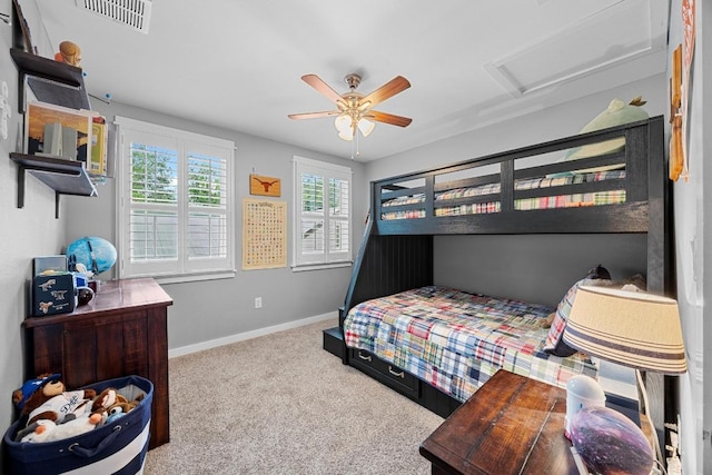 carpeted bedroom featuring visible vents, attic access, baseboards, and a ceiling fan