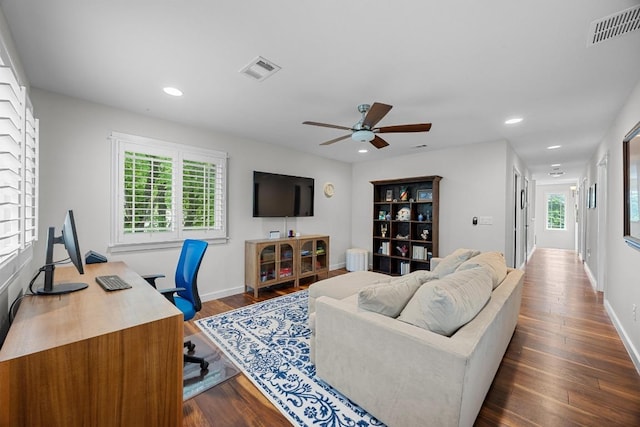 living area with visible vents, a ceiling fan, and a healthy amount of sunlight