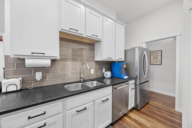 3907 Becker Ave, Austin, TX 78751 - kitchen with stainless steel appliances, white cabinets, wood finished floors, and backsplash