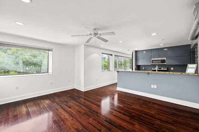 unfurnished living room featuring recessed lighting, baseboards, a ceiling fan, and dark wood finished floors